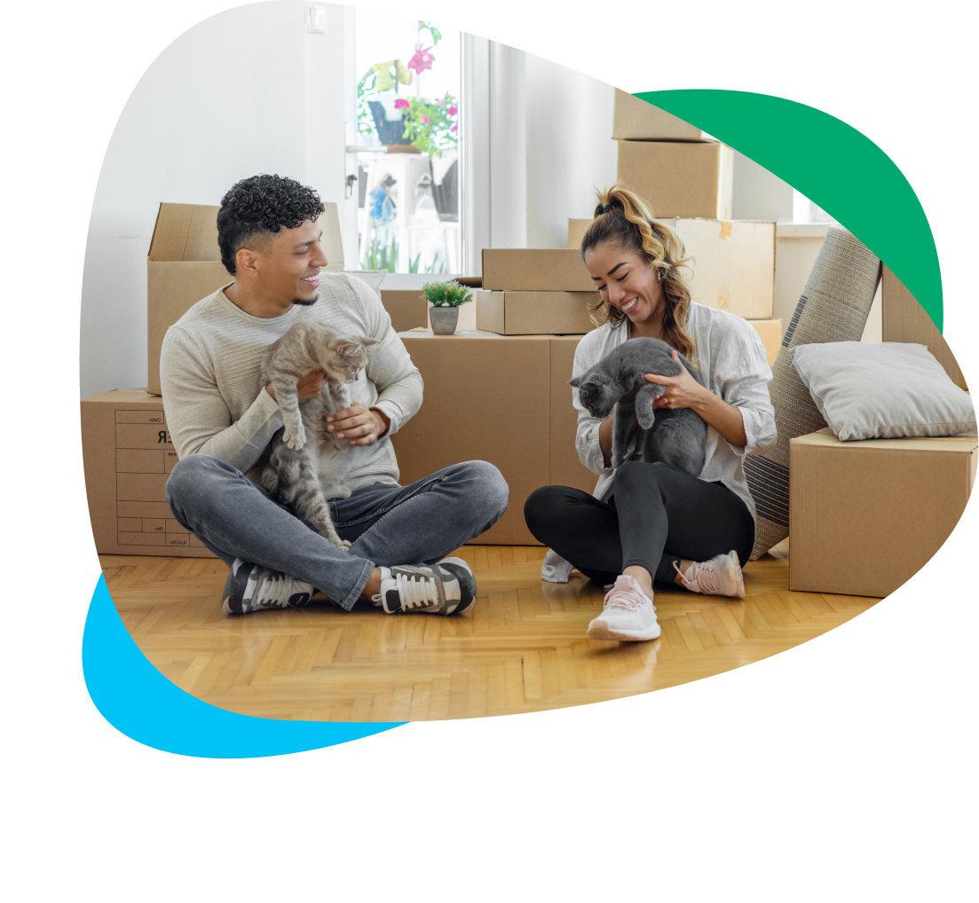 Couple sitting on the floor with cats and boxes